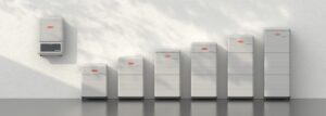 Växelriktare monterad på vägg tillsammans med flera batterimoduler i olika storlekar